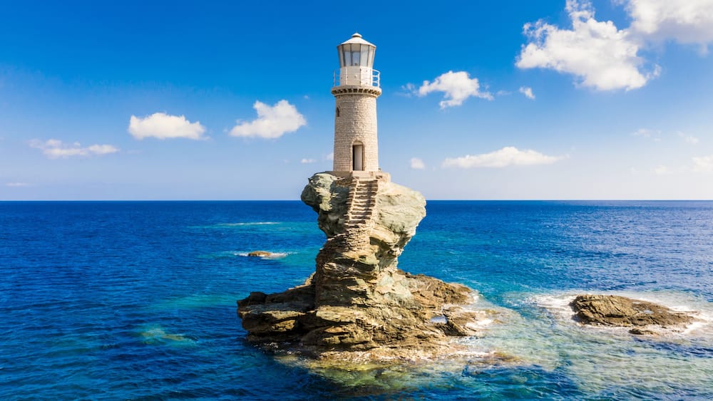 The beautiful Lighthouse Tourlitis of Chora at night. Andros island, Cyclades, Greece