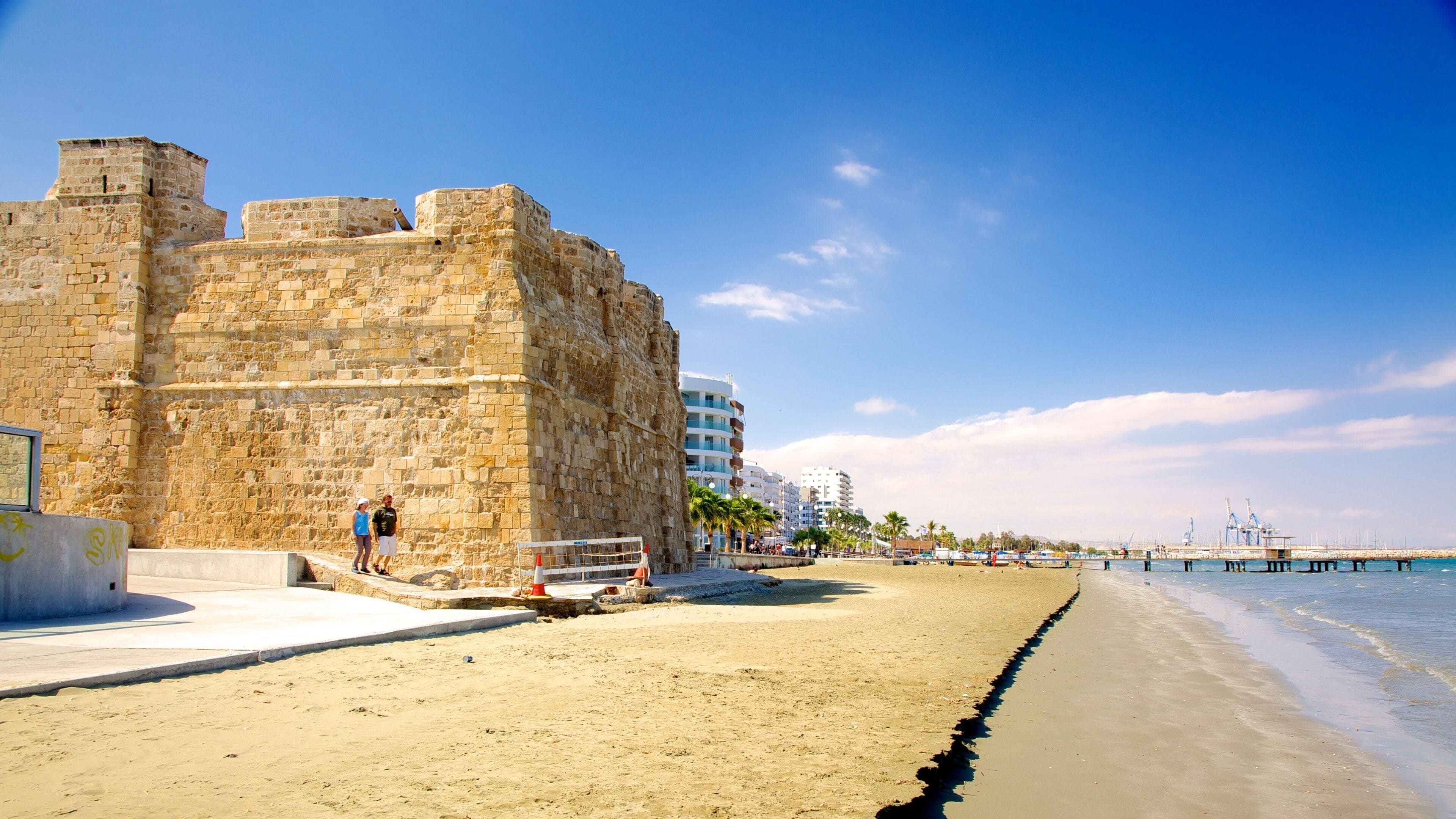 Fuerte de Larnaca ofreciendo una playa de arena, arquitectura patrimonial y vistas de una costa