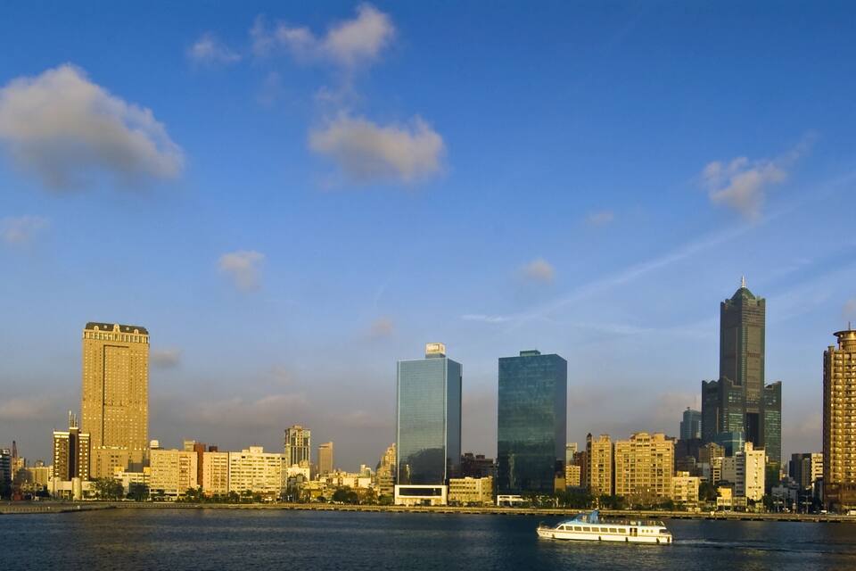 Horizontale Stadtansicht mit hohen Gebäuden und einem Fluss.