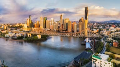 Paisagem urbana com rio, uma ponte e um horizonte de arranha-céus.