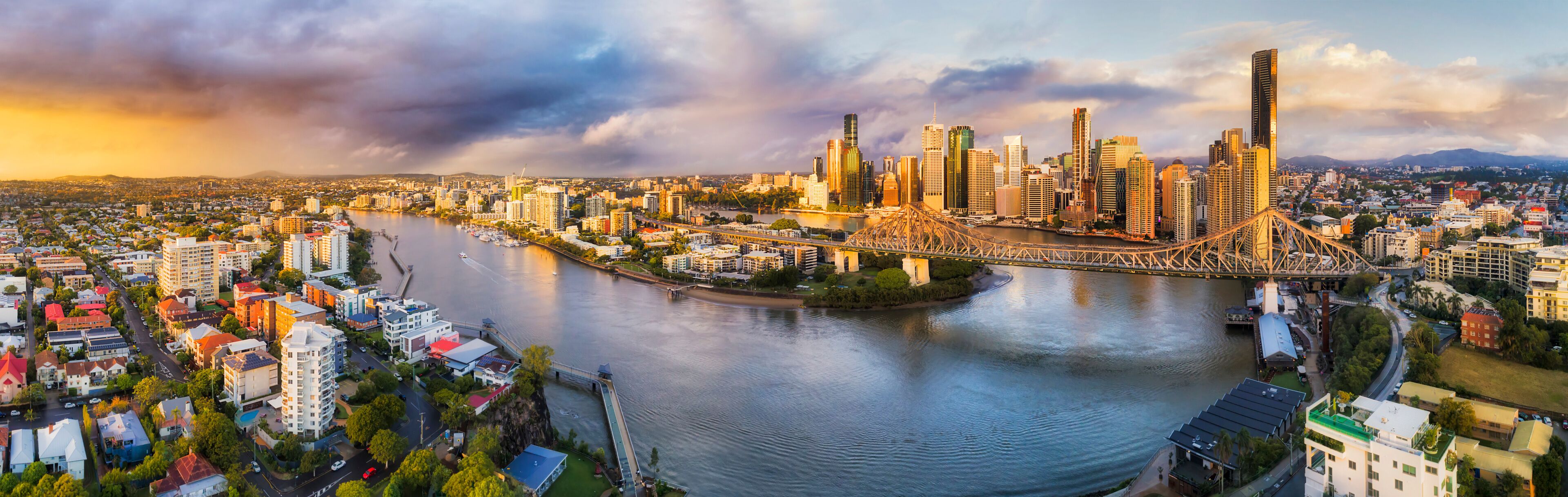 A cityscape with a river, a bridge, and a skyline of high-rise buildings.