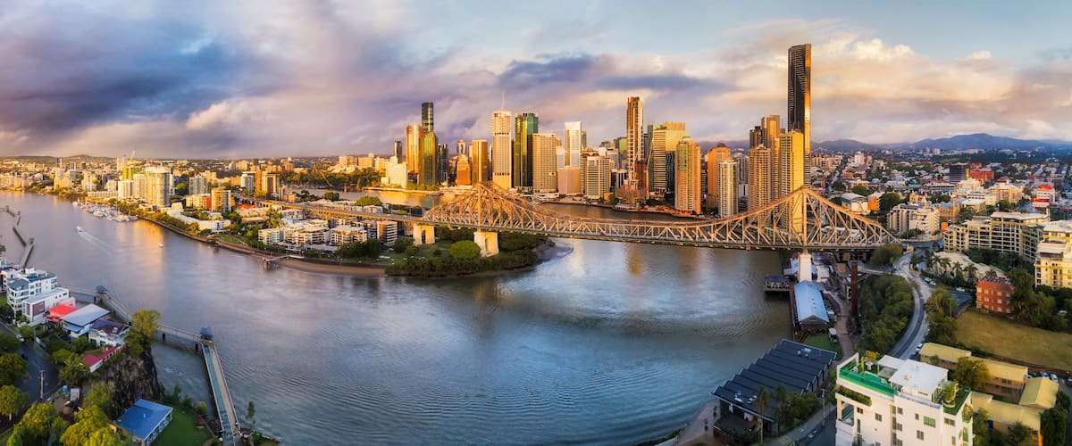 A cityscape with a river, a bridge, and a skyline of high-rise buildings.