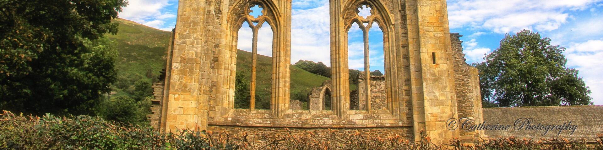 Beautiful and well preserve Abbey ruins in North Wales, hiking for a few hours and taking a break at roaming around the ruins -a worth a visit #ruins #nationalpark #travel #Wales #hiking #red #architecture