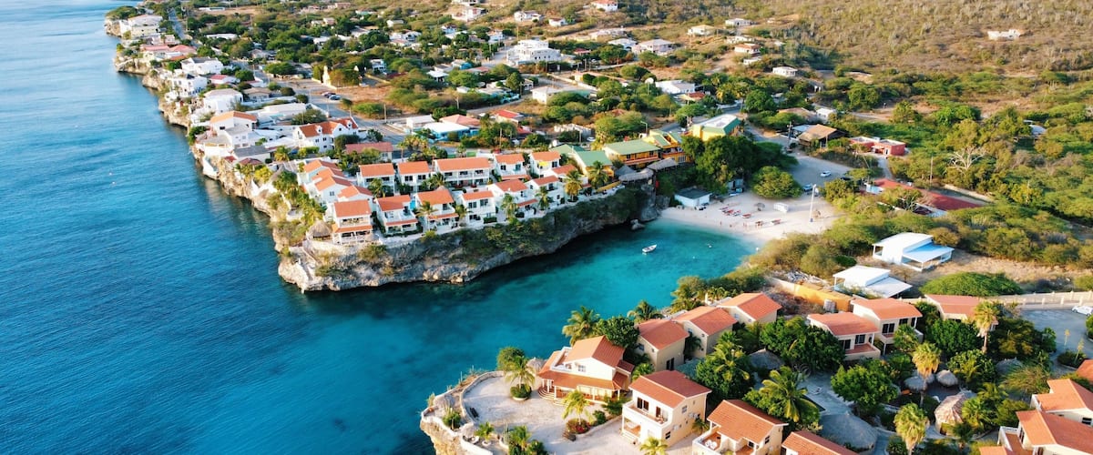 A coastal town with buildings along the cliffs and a beach area.