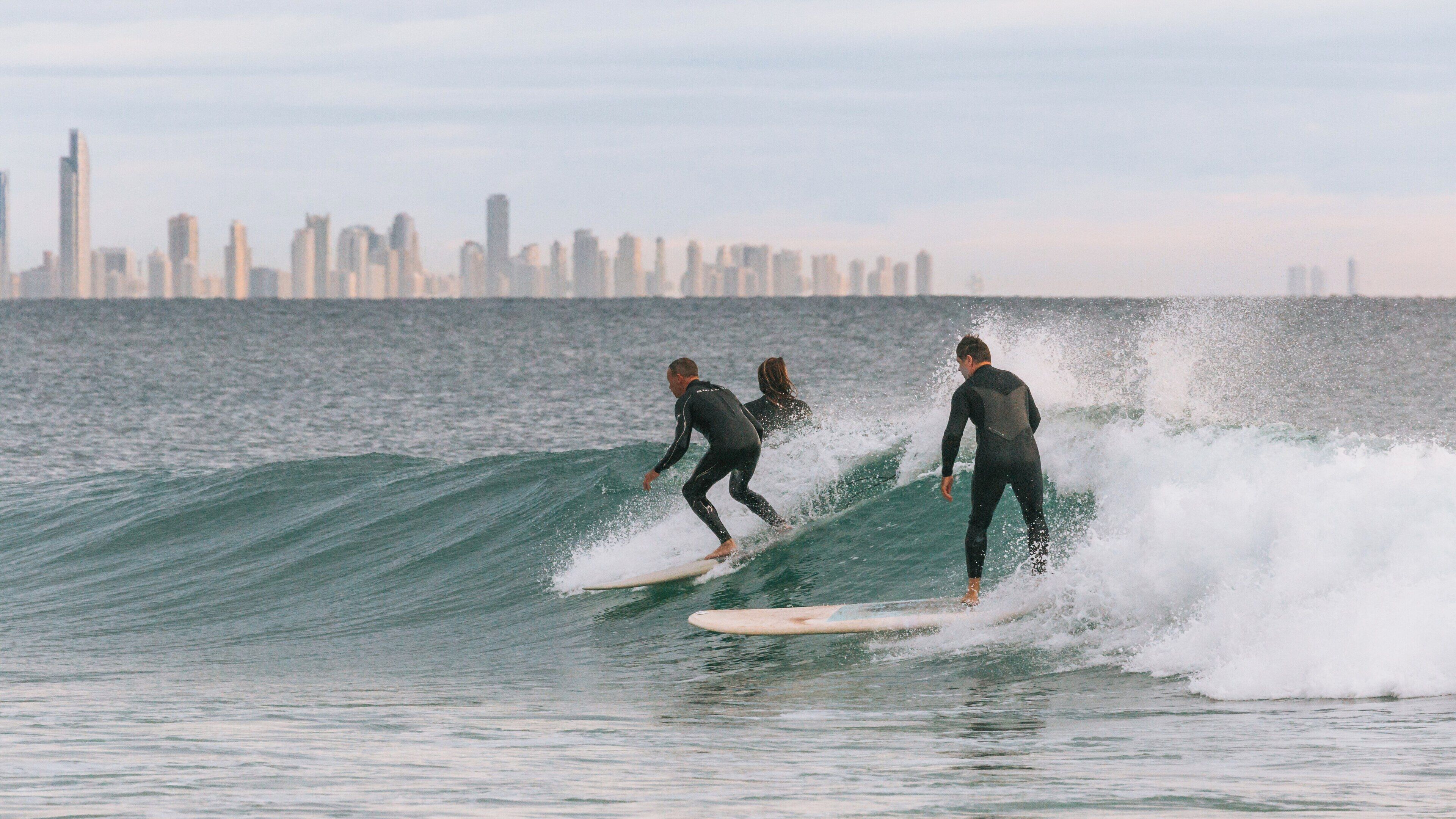 Surfers riding waves at Snapper Rocks, Coolangatta on the Gold Coast of Queensland, Australia under clear skies during the early morning light
