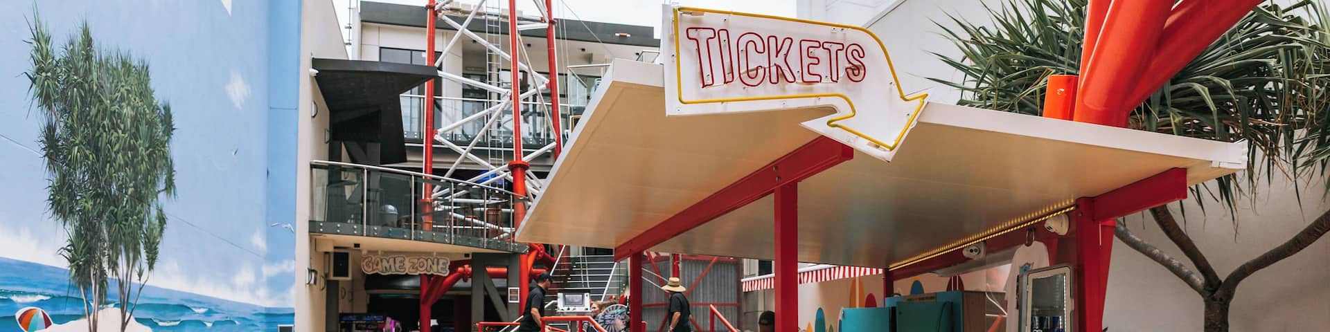 A ticket booth with a sign for 'TICKETS' and a 'SLINGSHOT' game area.