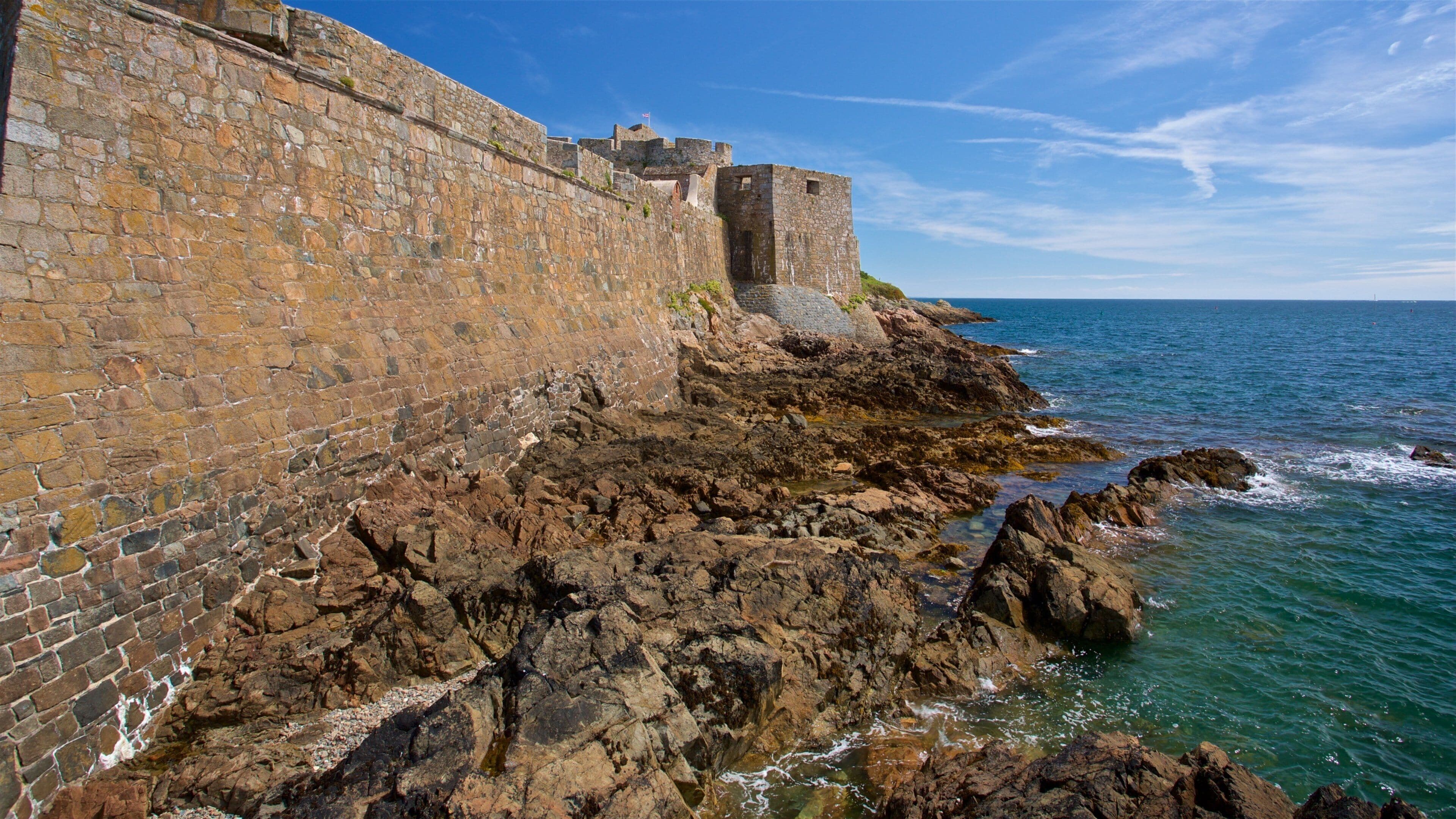 Castle Cornet which includes general coastal views and rocky coastline