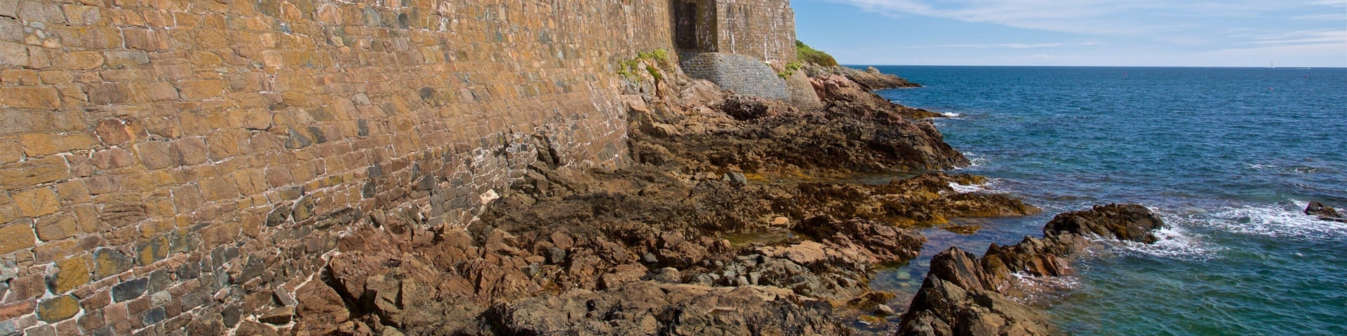 Castle Cornet which includes general coastal views and rocky coastline
