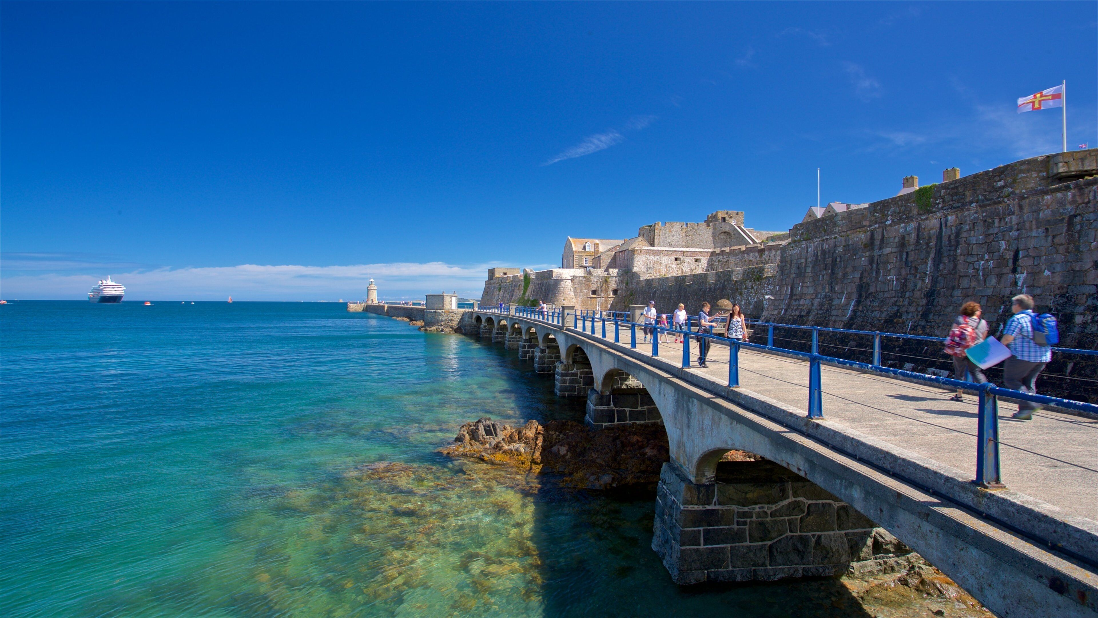 Castle Cornet which includes a bridge and general coastal views as well as a small group of people