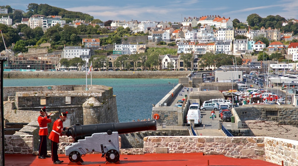 Castle Cornet mostrando artículos militares, elementos del patrimonio y una ciudad costera