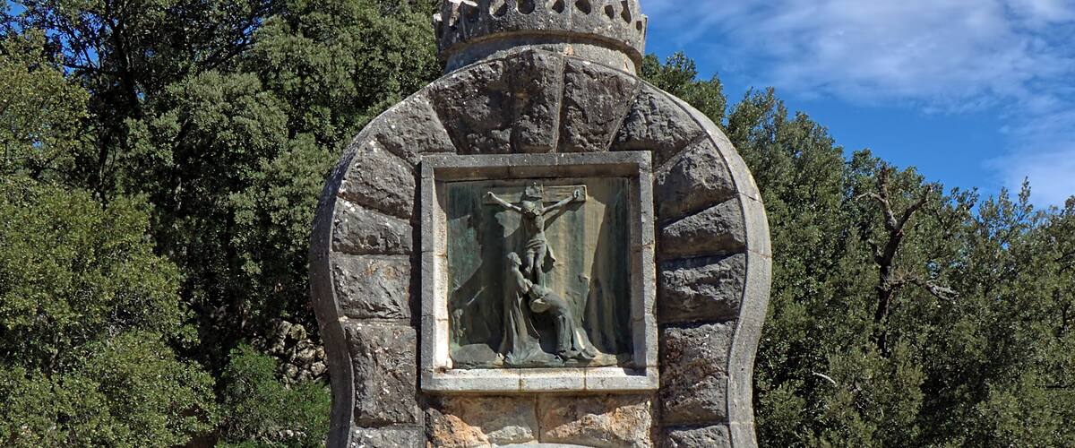 Last monument of the "Camino del Monte del Rosario", Santuari de Lluc, Escorca, Majorca. The inscription is a part (the fifth stanza) of the hymn "In monte olivis consito", composed by Fr. Augustine Thomas Ricchini (1695-1779) in 1757: Confixus atro stipite inter scelestos innocens, orando pro tortoribus, exsanguis efflat spiritum. (Nailed to the wood of ancient curse, between two thieves the Sinless One still praying for His murderers, breathes forth His soul, and all is done!).
