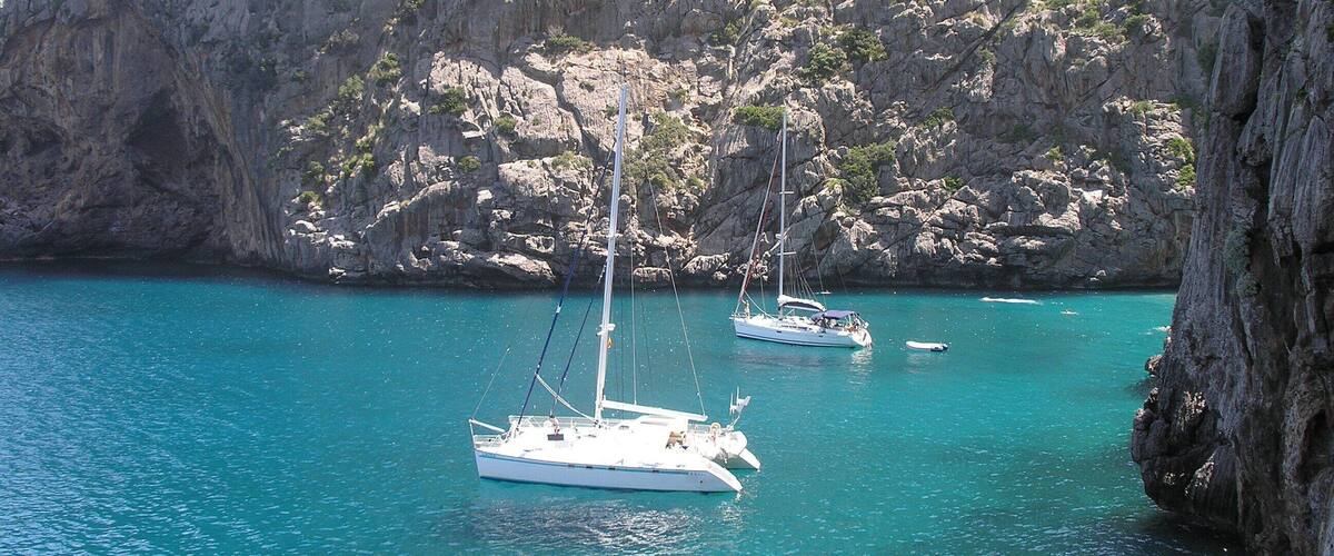 A coastal scene with rocky cliffs and clear turquoise waters.