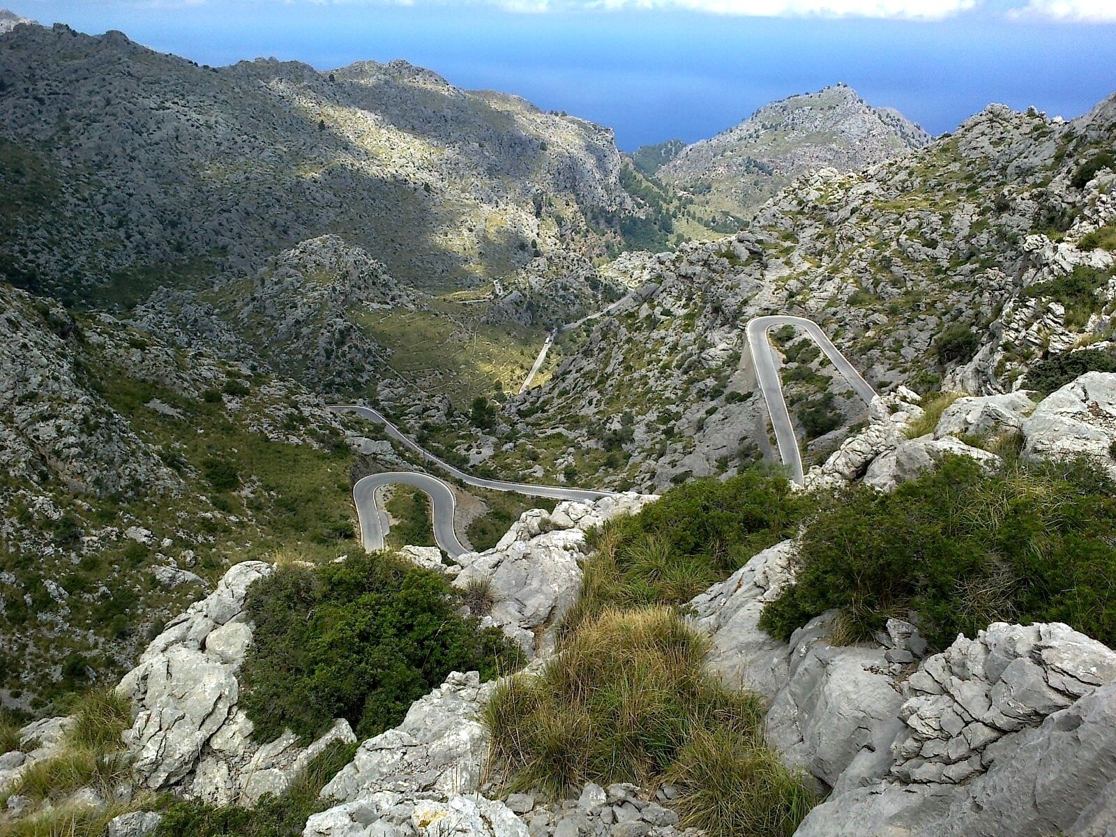 Una carretera sinuosa entre montañas, rodeada de terreno rocoso y vegetación escasa.