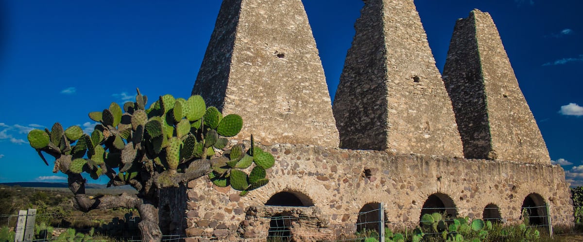 A stone structure with three tall towers and arched openings.