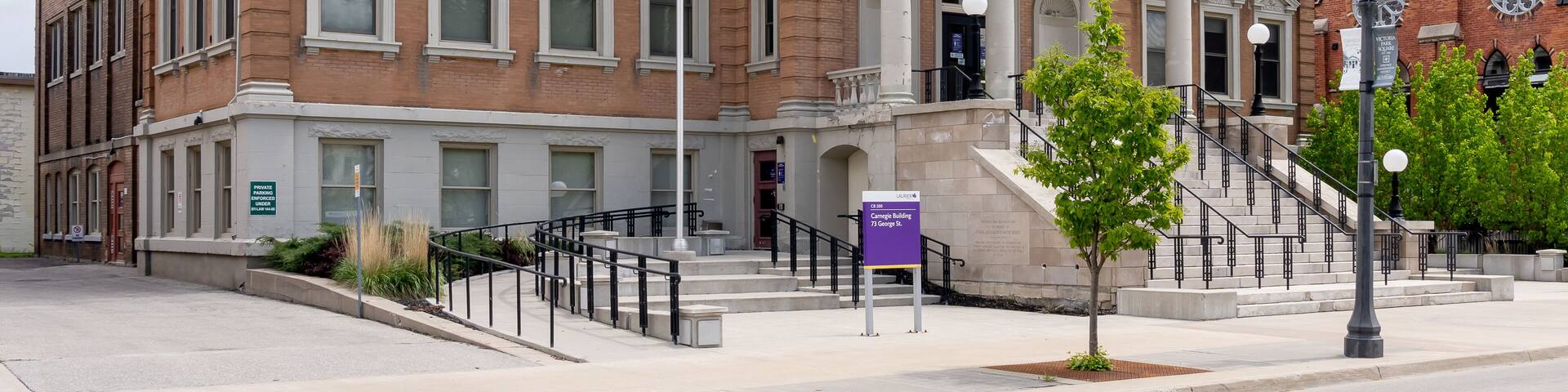 A historic library building with a dome, columns, and a staircase leading to the entrance.