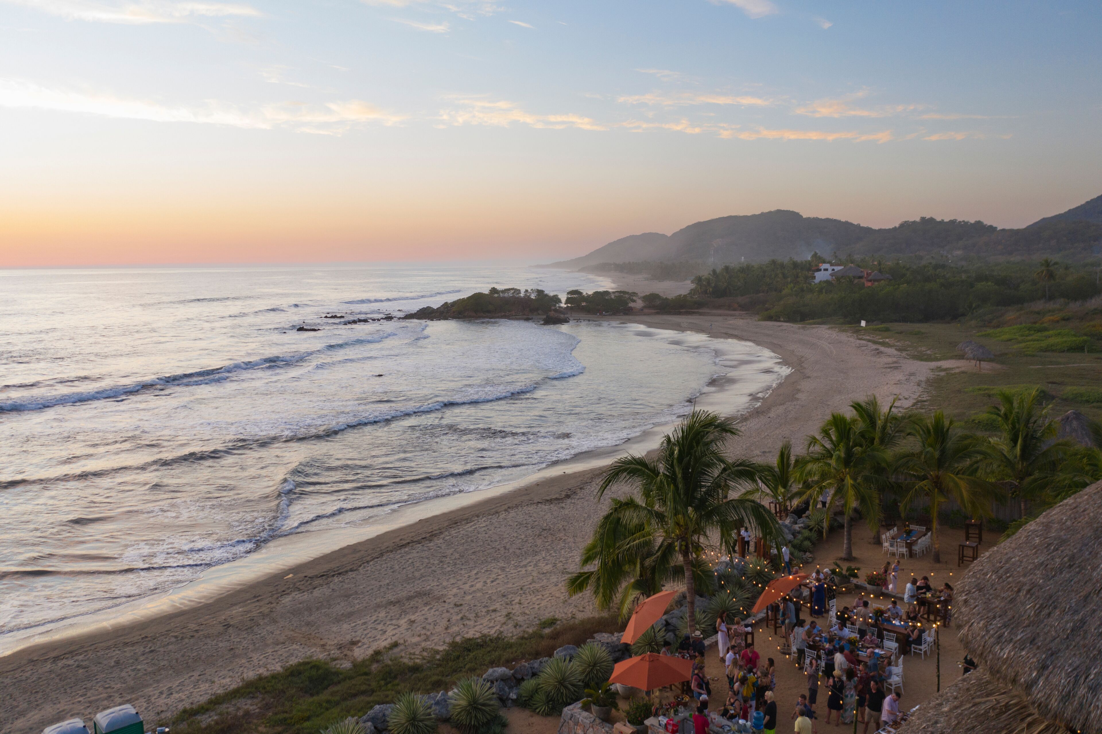 Aerial view of a beautiful beach with palm trees at sunset, Troncones, Guerrero, Mexico.