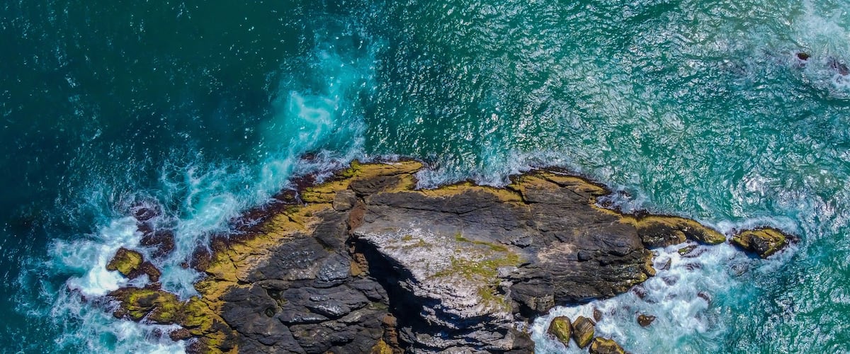 A rocky island surrounded by turquoise waters.