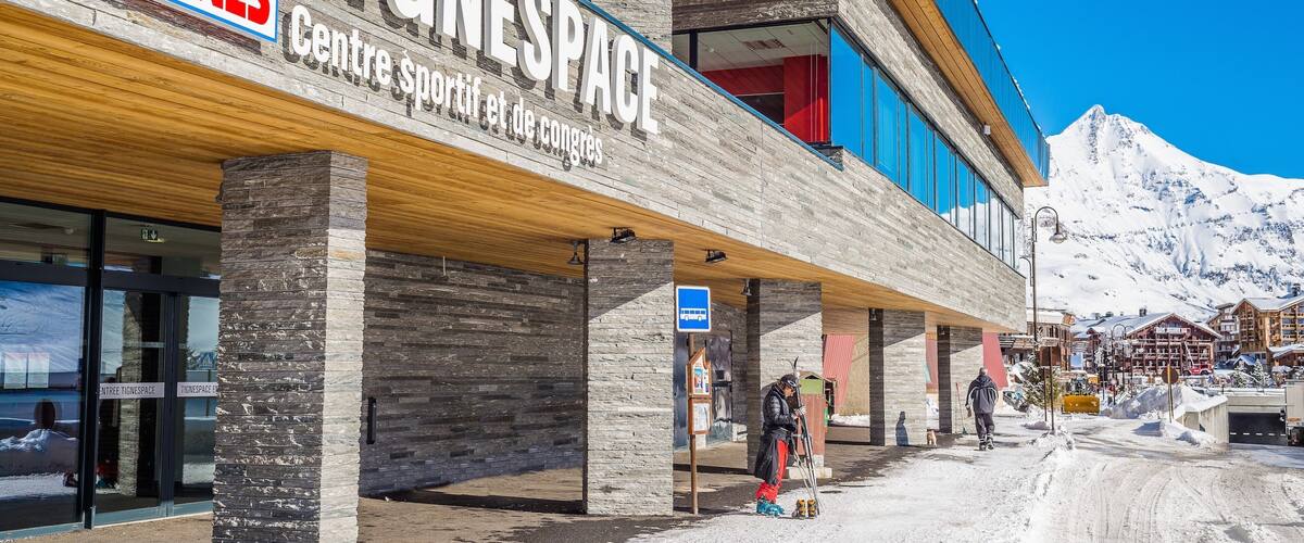 A Tignes sports center with a mountain backdrop.