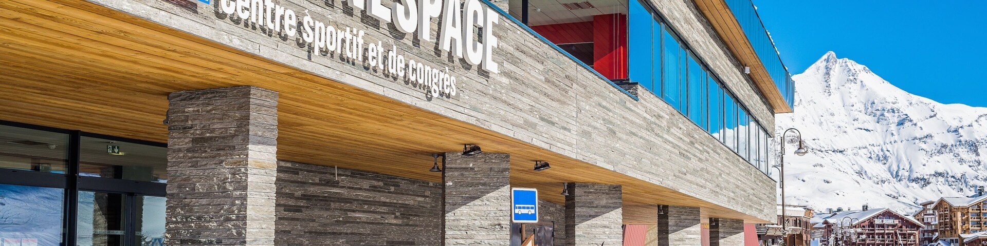 A Tignes sports center with a mountain backdrop.