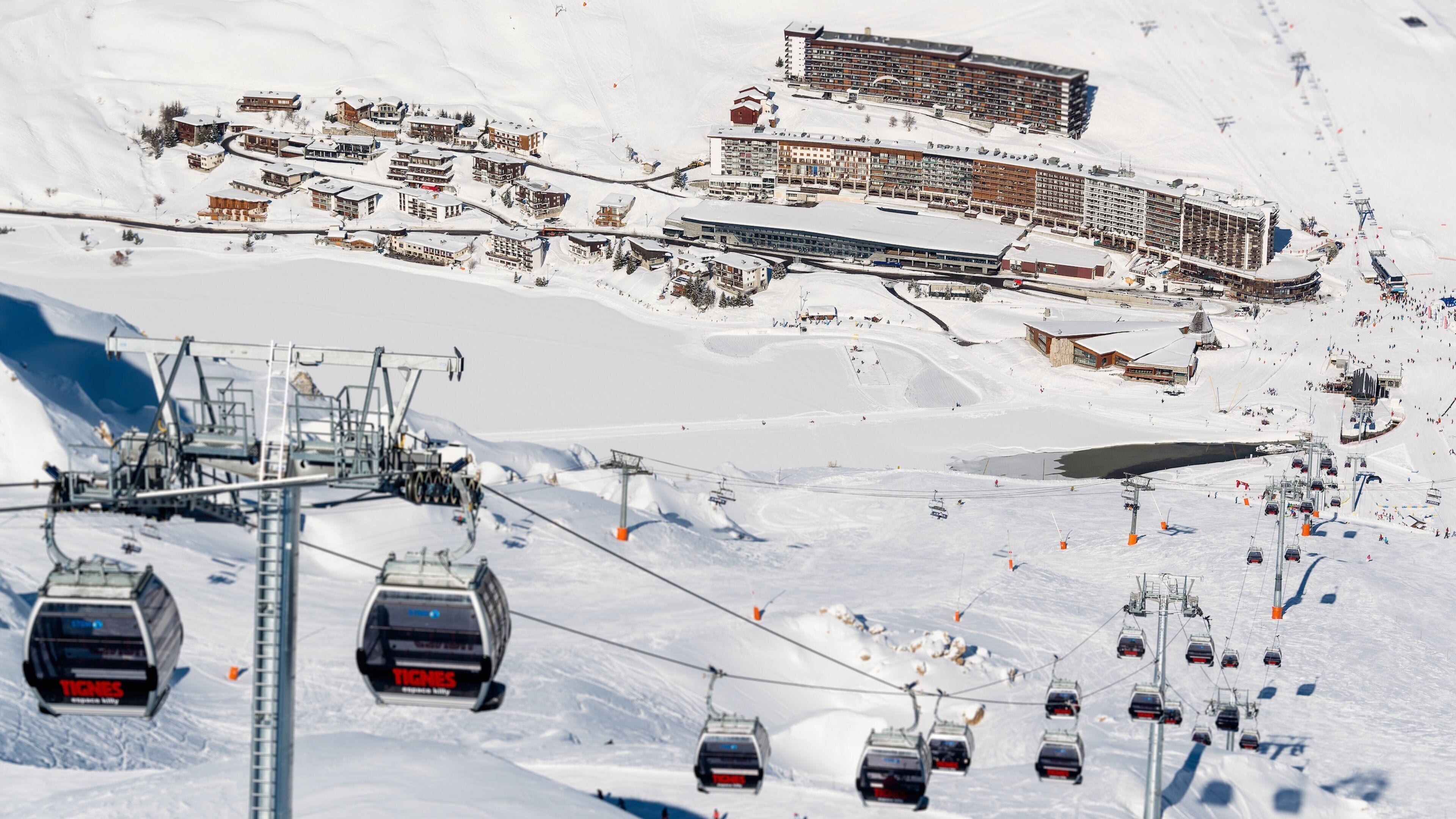 Estación de esquí nevada con telesillas, edificios y una pista de esquí.