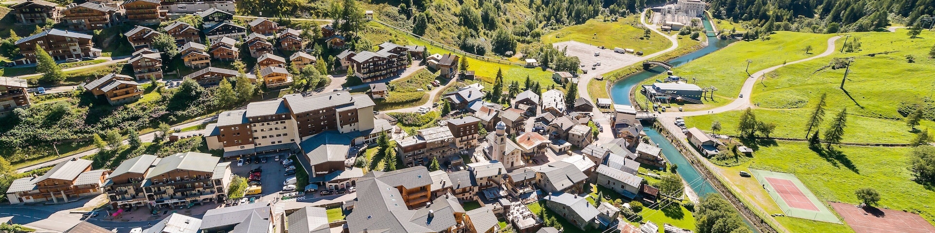 Tignes skiområde fasiliteter samt liten by eller landsby og elv eller bekk