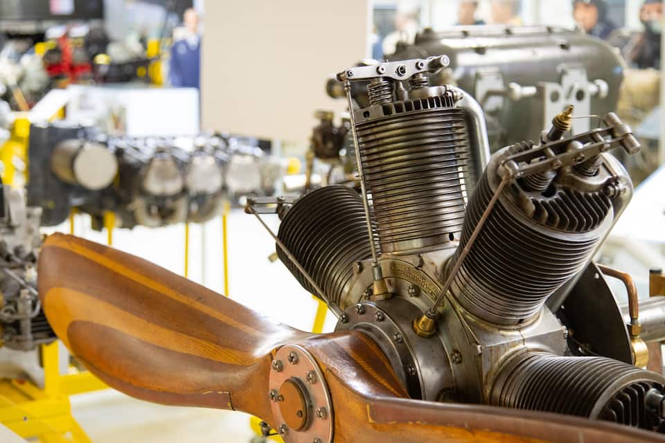 En detaljerad motor med synliga komponenter och en träpropeller.