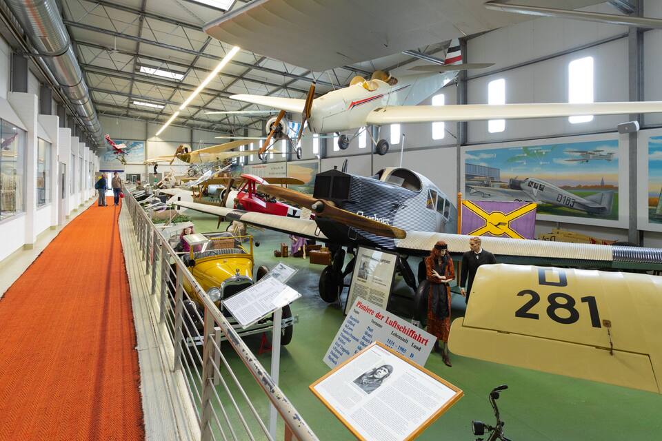 An indoor aviation museum with various aircraft on display.
