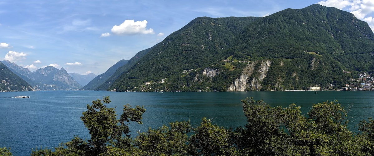 A lake surrounded by mountains with a boat on the water.