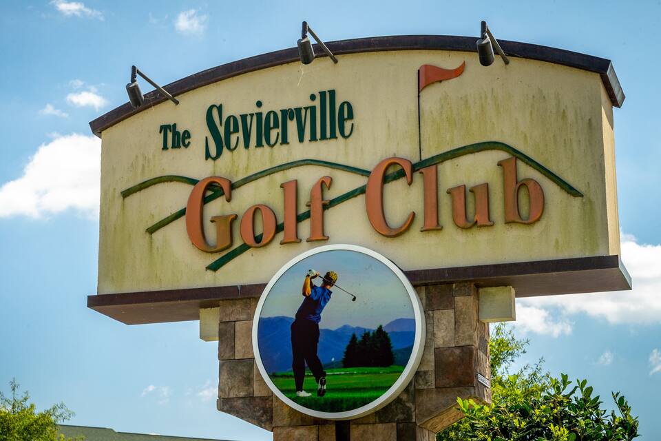Placa do Sevierville Golf Club com um golfista num destaque circular.