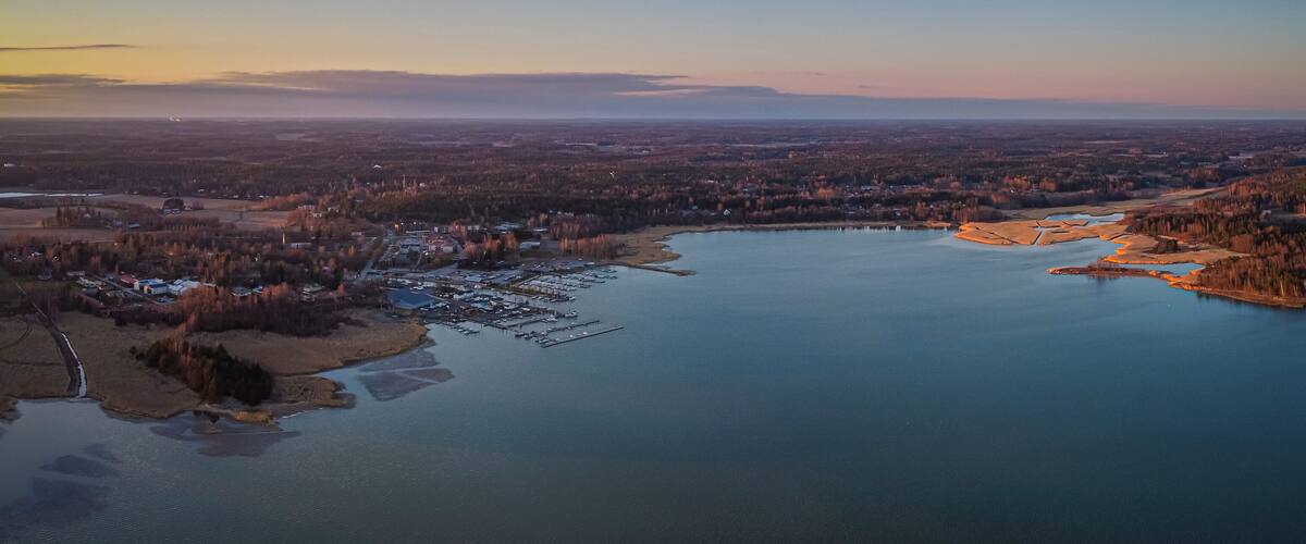 An aerial view of a lake surrounded by forested areas and a small town with docks.