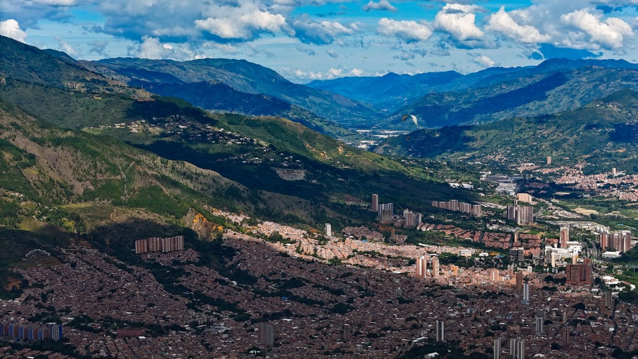 Paesaggio montuoso con una città incastonata nella valle.