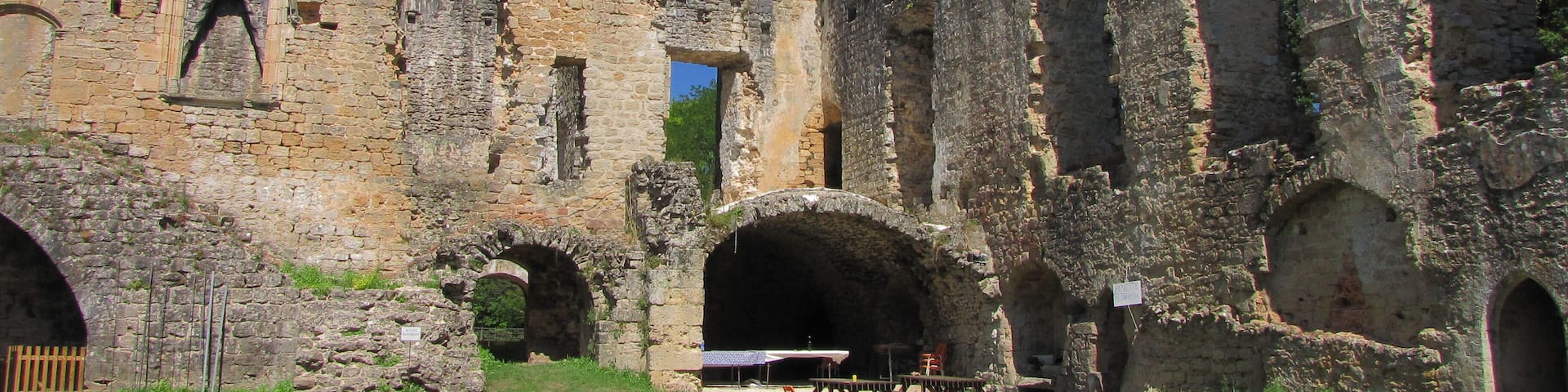 An ancient stone castle with arched windows and a tower.