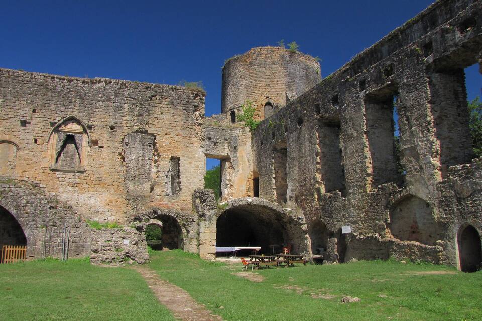Un castillo antiguo de piedra con ventanas de arco y una torre.