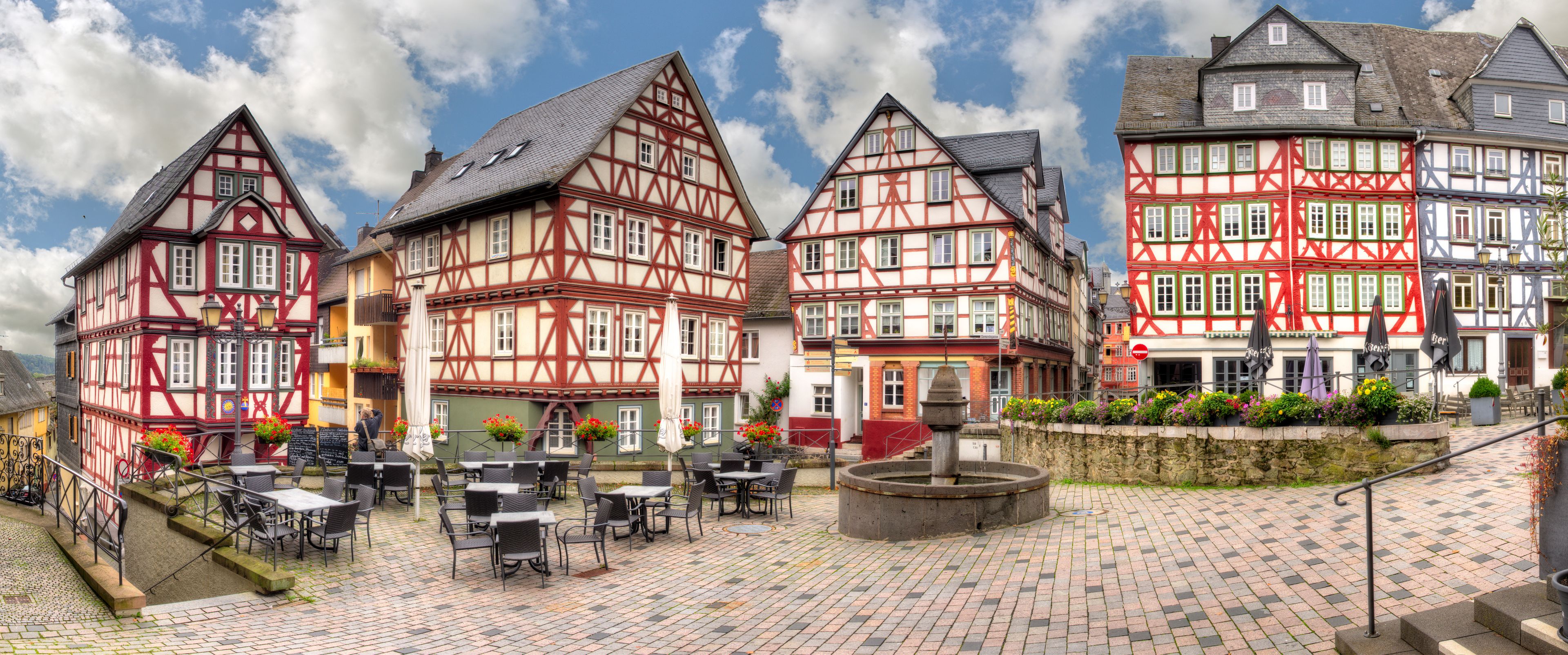 Ensemble von Fachwerkhäusern, am Kornmarkt in der historischen Altstadt von Wetzlar, Hessen mit einem menschleeren Straßencafe