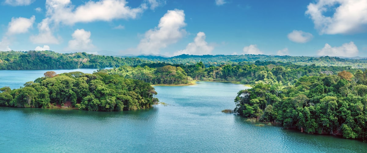 A tropical island landscape with clear blue waters and lush green vegetation.