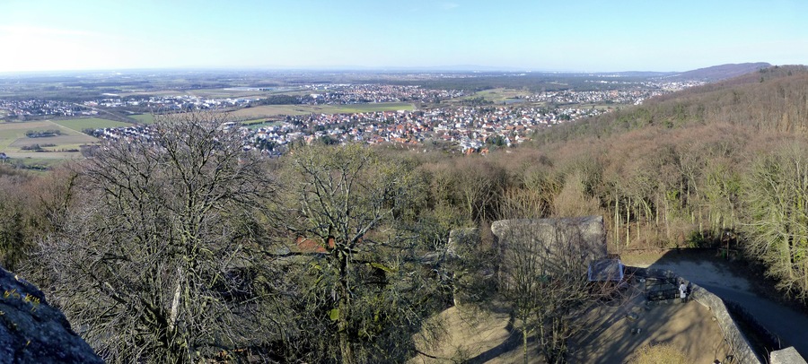 A panoramic view of a town nestled in a valley, surrounded by hills and sparse trees.