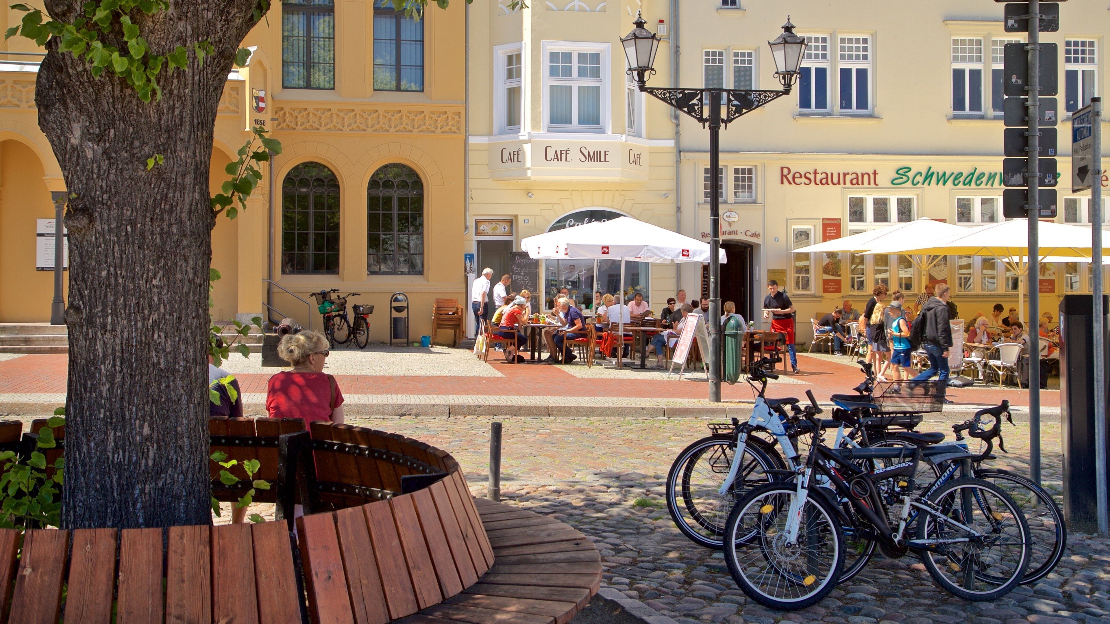 Wilsmer Market Square which includes outdoor eating as well as a small group of people