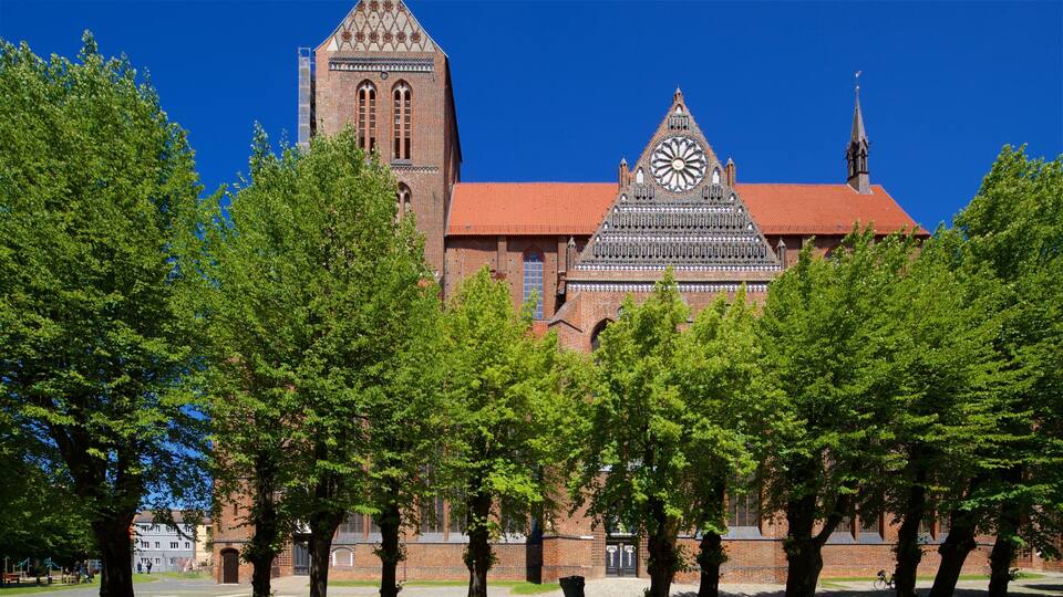 Een historisch gebouw met een klokkentoren en een grote roosvenster.