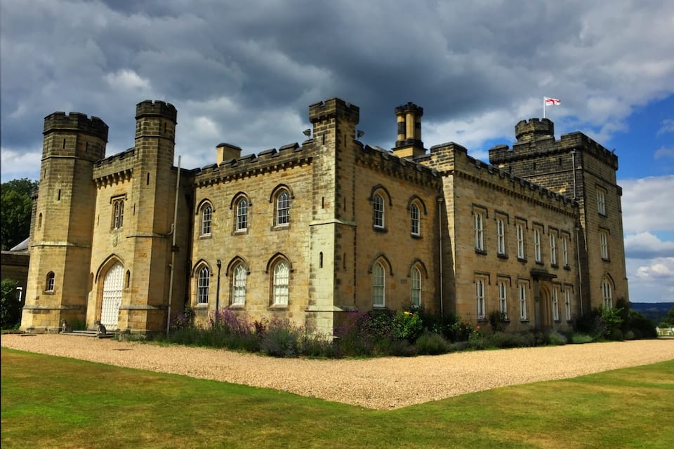 A large stone castle with multiple towers and arched windows.