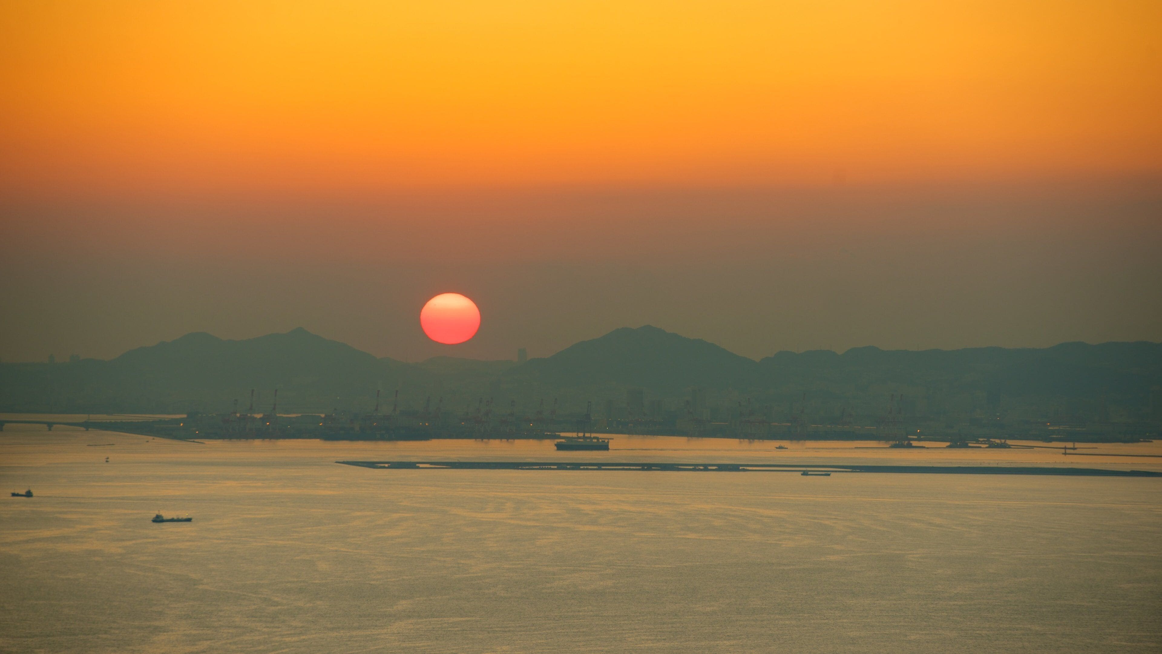Osaka Prefectural Government Sakishima Building which includes a sunset and a bay or harbour