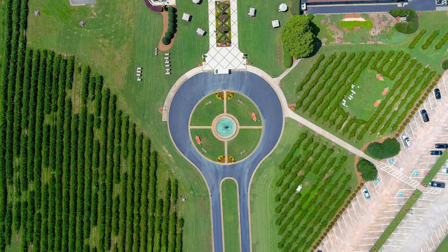 aerial shot of a circular driveway with a water fountain in the center at a vineyard surrounded by lush green trees, grass and plants at Chateau Elan Winery & Resort in Braselton Georgia USA