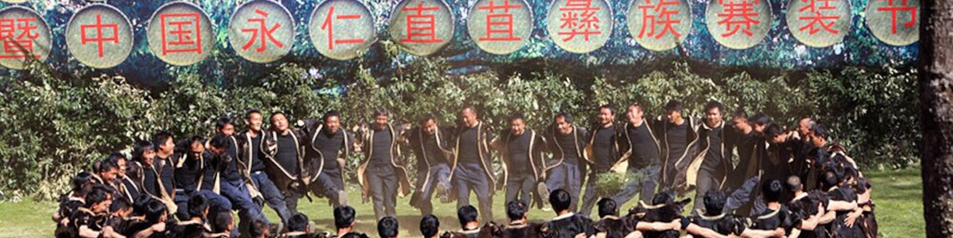 Un grupo de personas en círculo al aire libre, con un fondo de letreros circulares con texto.