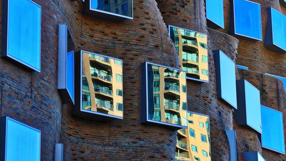 A modern building with a unique brick facade and multiple rectangular windows.