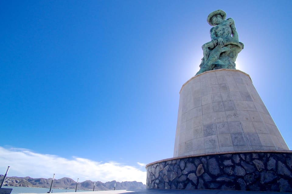 Una estatua sobre un pedestal con un cielo azul despejado al fondo.