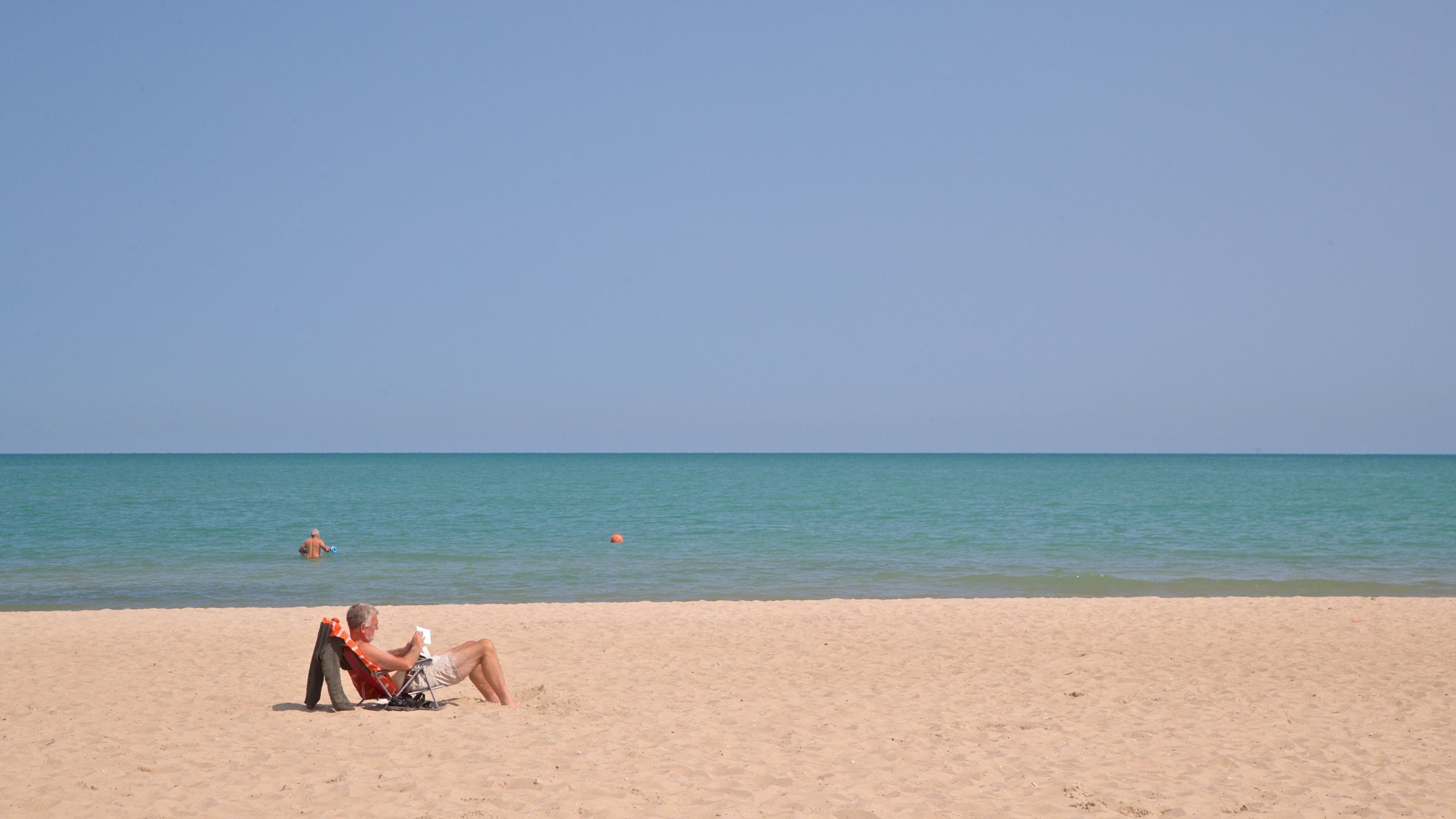 Grosse Point Lighthouse showing a sandy beach and general coastal views as well as an individual male