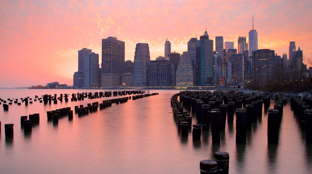 Brooklyn Bridge Park som visar en å eller flod, ett höghus och en solnedgång