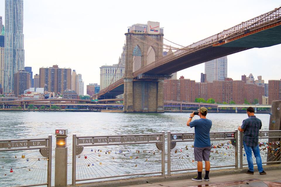 A bridge over a river with a city skyline in the background.