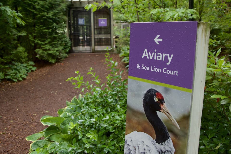 A sign for Aviary & Sea Lion Court with a bird illustration.