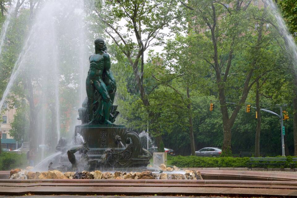 A statue with water jets in a park.
