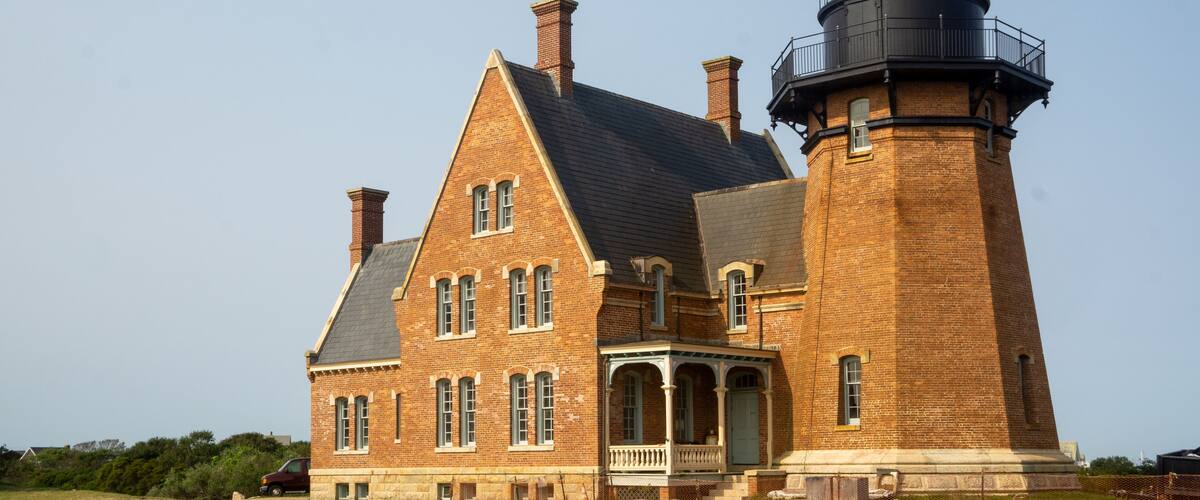 Block Island, RI / United States - Sept. 15, 2020: A landscape view of Block Island Southeast Light, a lighthouse located on Mohegan Bluffs, designated a U.S. National Historic Landmark in 1997.